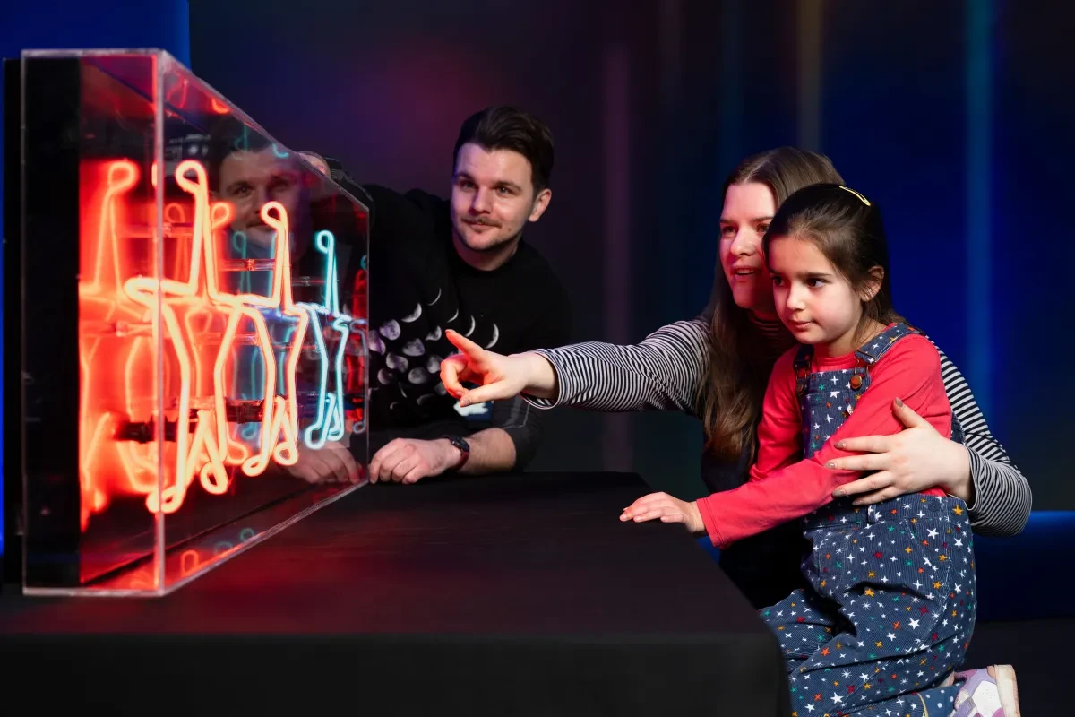 A mum and daughter enjoy a light show alongside an astronomer, part of Astronomers Take Over at the National Maritime Museum