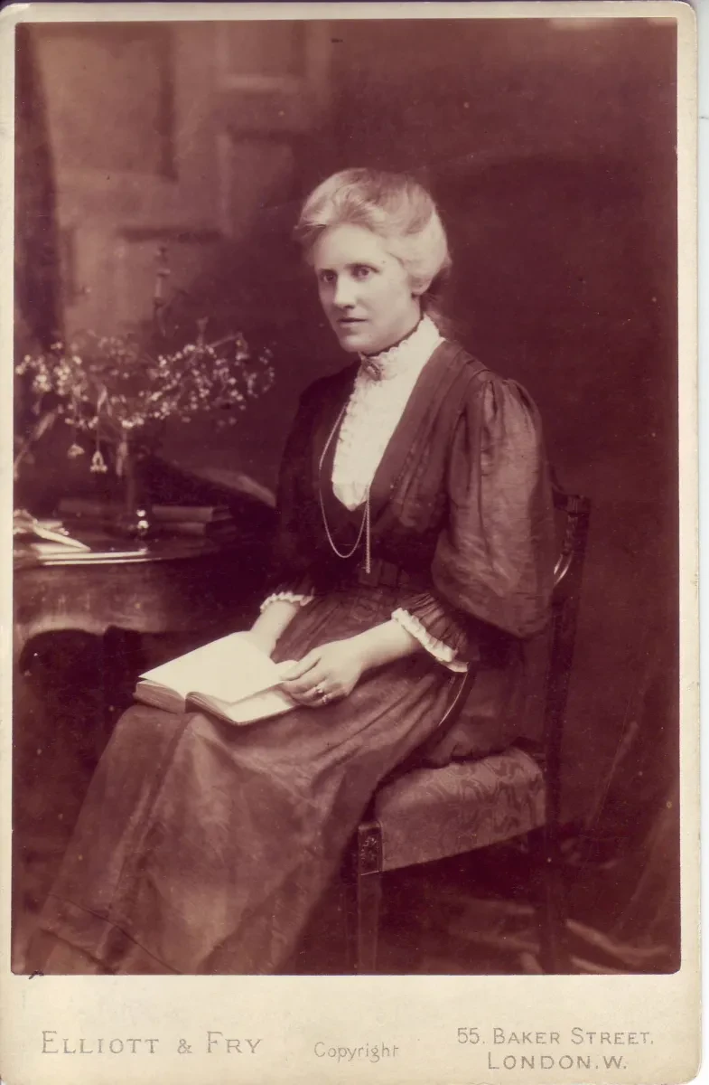 Sepia photograph of Annie Maunder, seated, with a book on her lap.