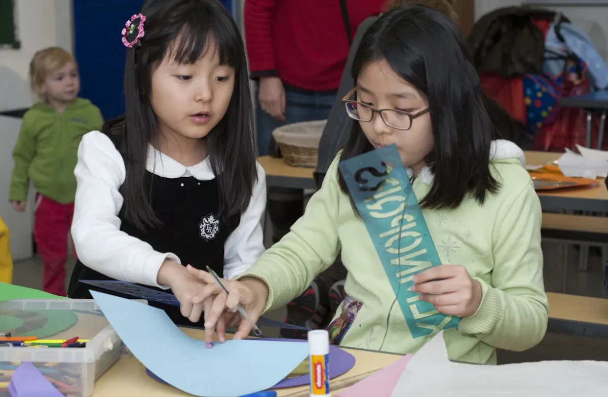 Two children play with craft materials.