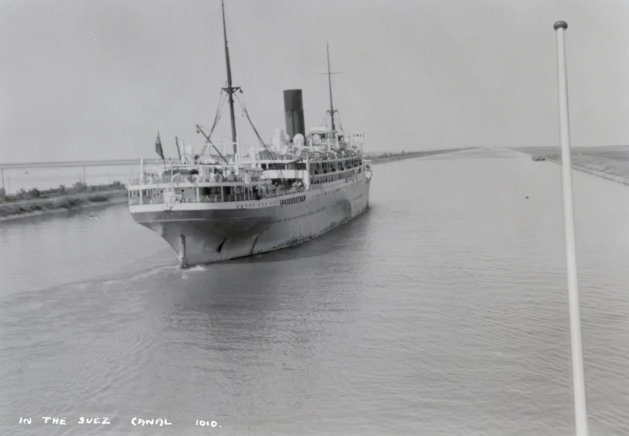 Black and white photograph of a ship transitting the Suez Canal